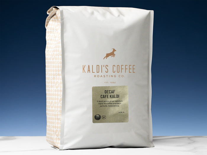 Kaldi's Decaf Cafe Kaldi coffee bag with white packaging and a patterned side panel against a blue backdrop