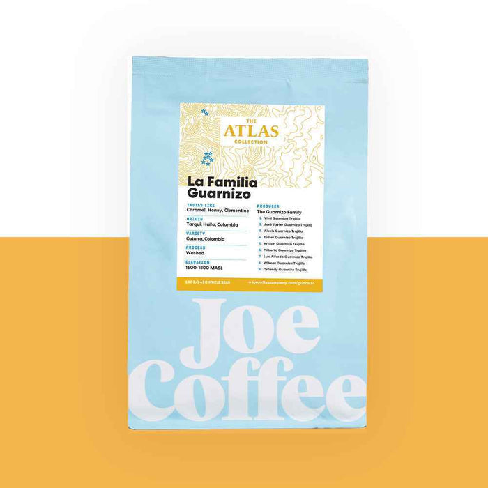 Blue coffee bag labeled La Familia Guarnizo Atlas Collection on an orange background
