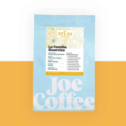 Blue coffee bag labeled La Familia Guarnizo Atlas Collection on an orange background