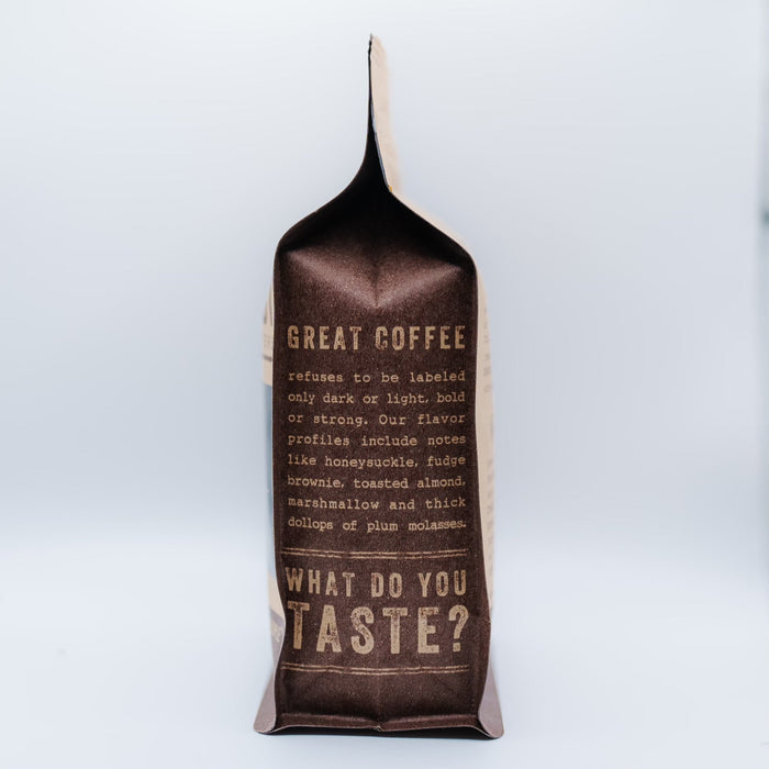 Edge on view of Barefoot Coffee Roasters packaging showing folded top and dark label against a pale backdrop