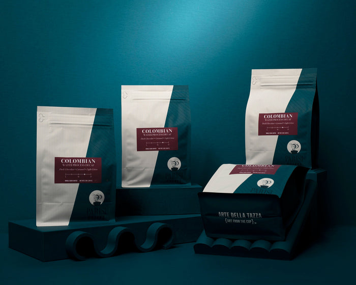 Colombian Decaf coffee bags stand against a teal backdrop.