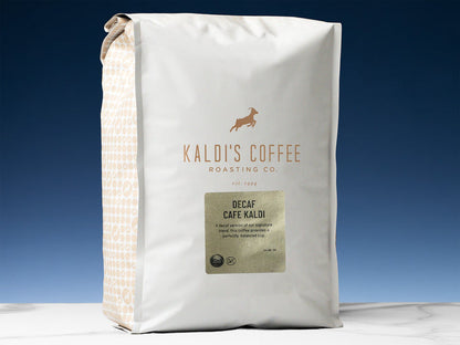 Kaldi's Decaf Cafe Kaldi coffee bag with white packaging and a patterned side panel against a blue backdrop