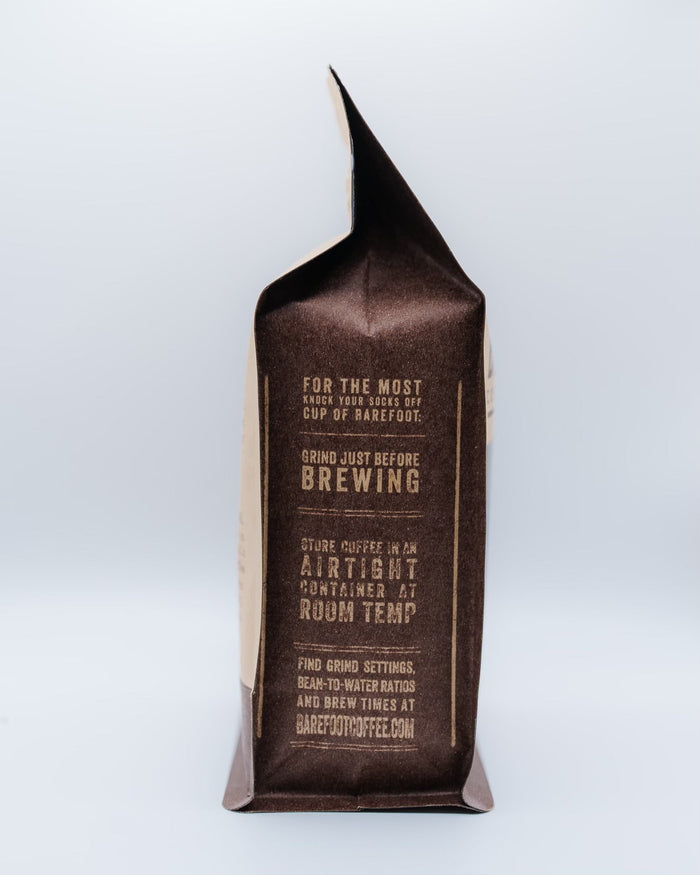 Decaf Colombia coffee bag with a folded top and brown label against a pale blue background