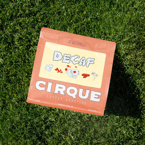 Cirque Coffee Roasters Decaf bag on grass with bold DECAF label