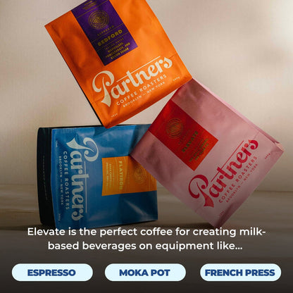 Three Partners coffee bags arranged diagonally Bedford orange Blue Flatiron and Elevate pink labels