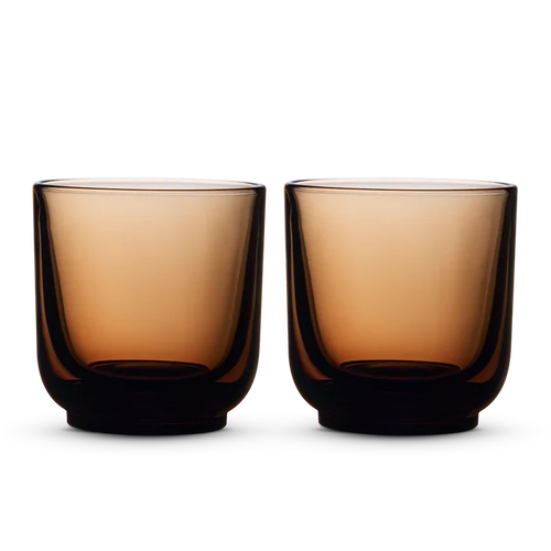 Two amber Fellow Pirch espresso shot glasses on a black background