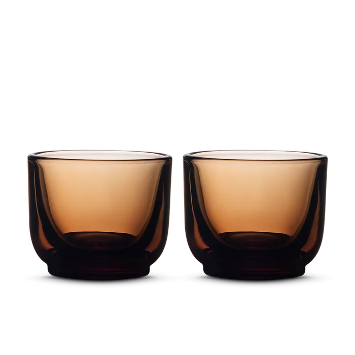 Pair of deep amber Fellow Pirch espresso shot glasses side by side