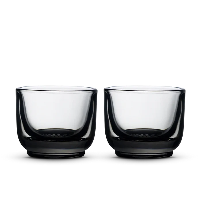 Pair of Fellow Pirch espresso shot glasses with pale green tinted bowls and dark bases