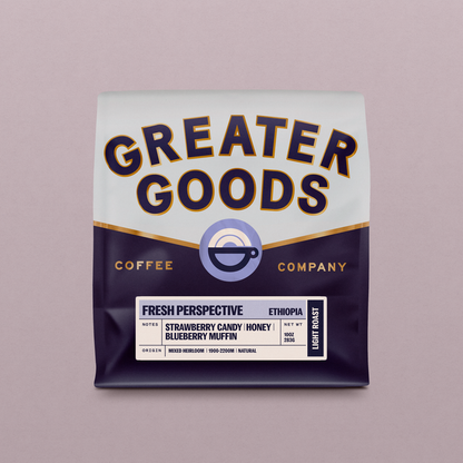 Close-up of a Greater Goods coffee bag showing bold typography and a cup logo on a pink backdrop