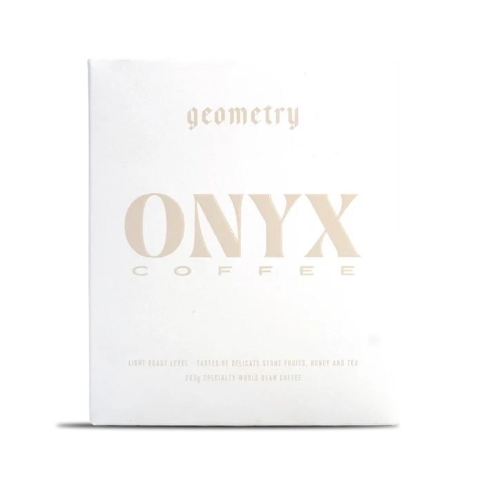 White Onyx Geometry coffee box with pale gold typography across the front
