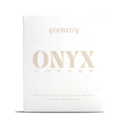 White Onyx Geometry coffee box with pale gold typography across the front