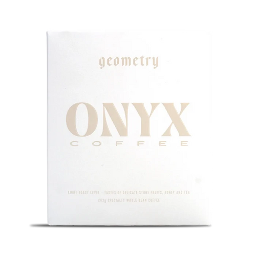 White Onyx Geometry coffee box with pale gold typography across the front