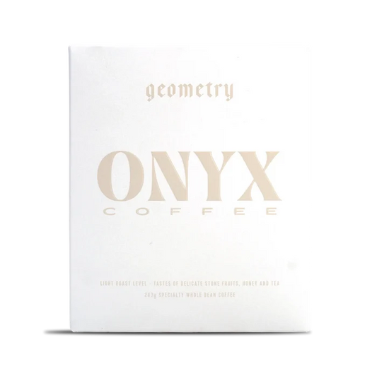 White Onyx Geometry coffee box with pale gold typography across the front