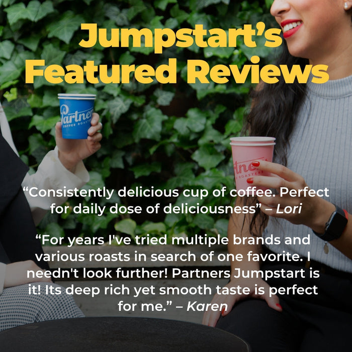 Two people enjoy coffee outdoors with a green leafy backdrop and a Jumpstart Featured Reviews banner in bold yellow letters