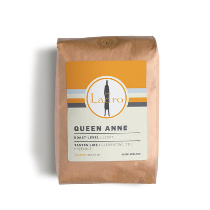 Queen Anne coffee bag with orange label and striped band featuring the Ladro circle logo