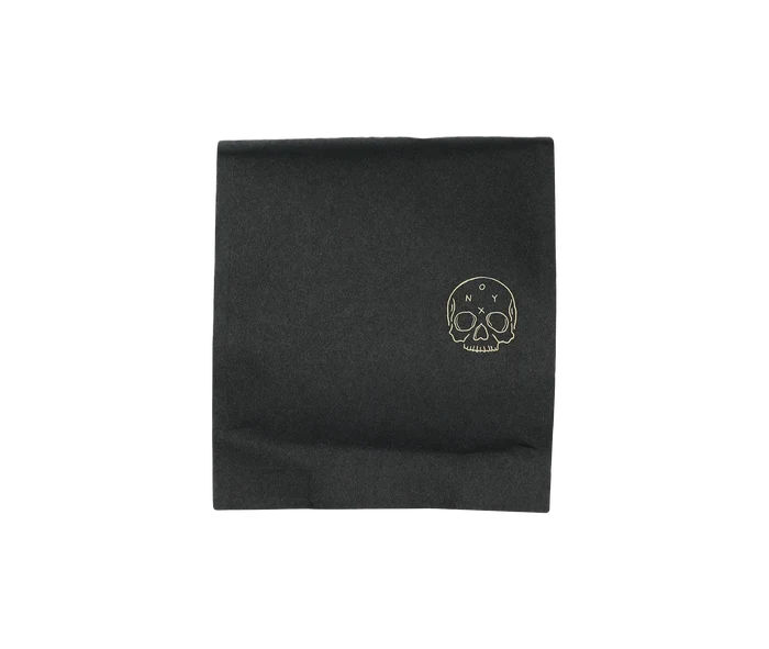 Black coffee bag featuring a gold skull logo and subtle brand mark